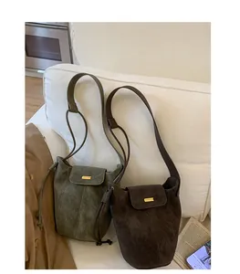 Detailed view of vintage matte drawstring bucket bags in olive green and dark brown colors