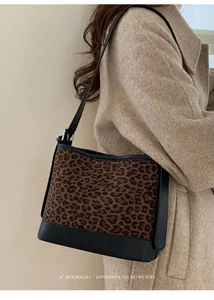 Retro leopard print tote bag with black leather trim shown on a model's shoulder