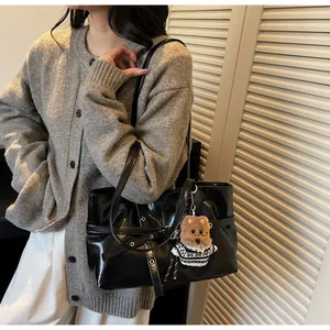 Détail du sac cabas en cuir ciré noir brillant avec pendentif ours pour femme élégante