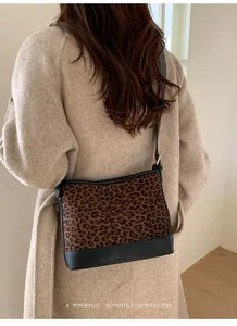 Detailed back view of a minimalist leopard print suede tote bag worn over the shoulder