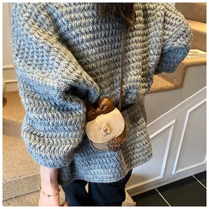 Dettaglio borsa a tracolla bambina con orsetto di peluche e fiocco in camoscio beige