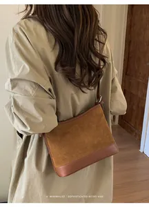 Brown suede and leather tote bag styled on model for a minimalist retro aesthetic look