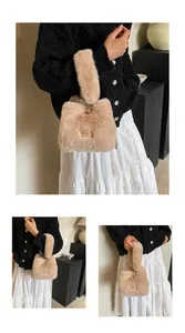 Detail van pluche faux fur emmertas in abrikooskleur met gouden logoplaatje erop