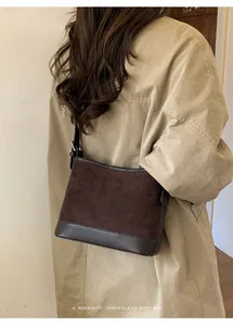 Detail of vintage brown suede and leather patchwork tote bag with minimalist silver buckle