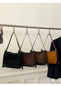Detailed display of vintage suede bucket bags in black, brown, leopard and yellow tones