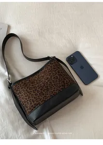 Detail view of leopard print suede shoulder bag with smartphone for size comparison