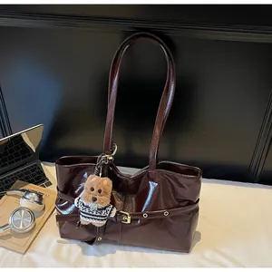 Détail du grand sac cabas marron foncé en cuir huilé avec pendentif ours en peluche