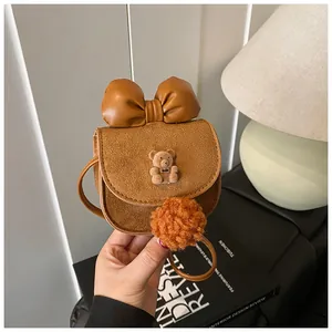 Dettaglio della mini borsa marrone scamosciata da bambina con fiocco e ciondolo orso