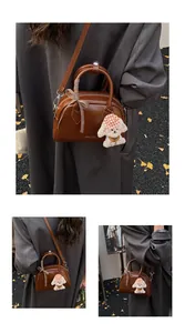 Detail of vintage brown leather pillow bag with bow and puppy pendant for women