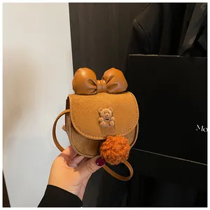 Dettaglio borsa a tracolla da bambina marrone con orsetto di peluche e pompon arancione