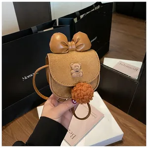 Dettaglio borsa bimbi in camoscio marrone con fiocco, orso 3D e morbido ciondolo pompon