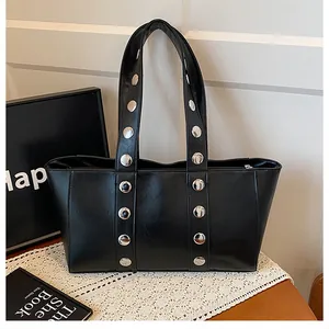 Detail of black tote bag with silver rivets on lace cloth showing smooth texture