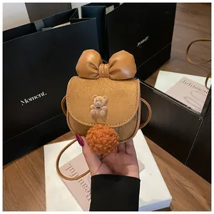 Dettaglio borsa a sella per bambini in pelle scamosciata con orsetto e pompon