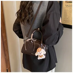 Detail of vintage brown leather pillow bag with ribbon bow and cute puppy charm