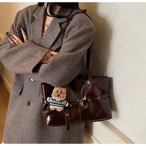 Détail du sac cabas en cuir ciré brillant avec breloque ours en peluche et boucle métal