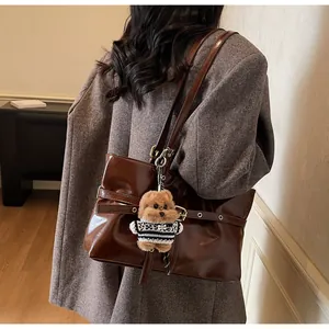 Détail du cabas en cuir ciré avec boucle métallique et breloque chien en peluche