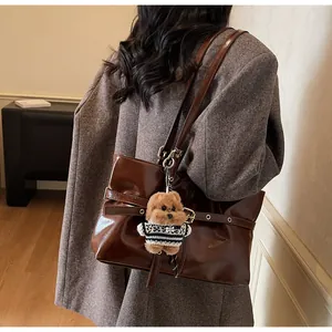 Détail du sac cabas en cuir ciré avec boucle métallique et pendentif ours en peluche