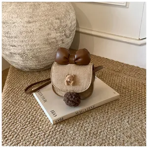 Dettaglio borsa bimbi scamosciata kaki con fiocco marrone e orsetto decorativo