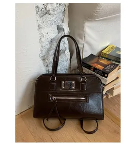 Macro detail of dark brown glossy leather tote with silver hardware and zip pocket