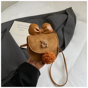 Vista dettagliata della mini borsa a tracolla cammello con fiocco in pelle e decoro orsetto