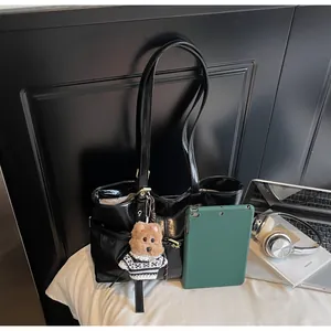 Détail du grand cabas en cuir ciré noir brillant avec pendentif ours et poche latérale