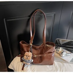 Sac cabas marron brillant avec boucle métallique et charmant ours en peluche