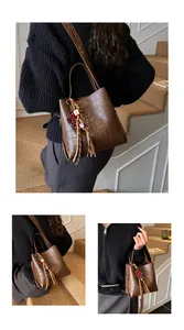 Detailed view of dark brown faux crocodile bucket bag with sequined bear and tassel charm