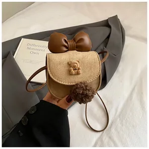 Dettaglio mini borsa a tracolla con orsetto, grande fiocco e accessorio con pompon morbido
