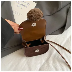 Mini borsa in pelle scamosciata marrone con pompon e chiusura magnetica per l'autunno