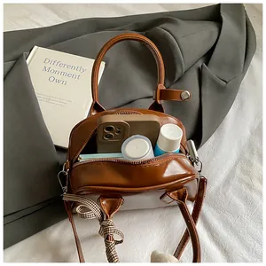 Brown vintage Boston bag showing interior capacity with phone and cosmetics