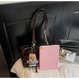 Détail du grand cabas rouge vin foncé en similicuir avec pendentif chiot en peluche