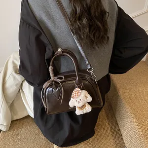 Retro dark brown pillow handbag with glossy finish, ribbon bow and cute plush puppy charm