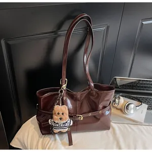 Détail du sac cabas en cuir ciré brillant avec charm ours mignon et sangle à boucle métal