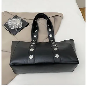 Detail of black PU leather tote featuring large silver studs and spacious bottom