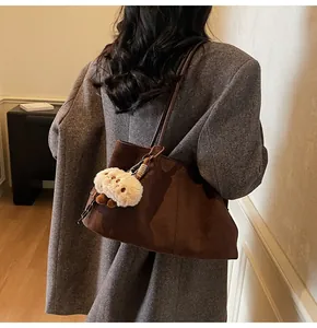 Brown suede tote bag with plush lamb charm shown on shoulder for daily commute style