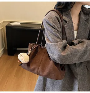 Brown suede tote bag worn with grey wool blazer for a professional commuter style