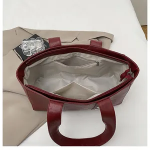 Top view of the spacious red tote bag interior featuring functional pockets and beige lining
