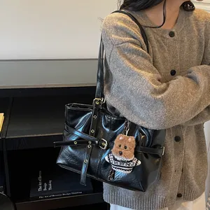 Sac cabas minimaliste en cuir ciré noir avec boucle en métal vintage et breloque peluche