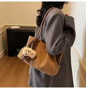 Brown suede tote bag with plush charm styled with a dark grey wool blazer for women