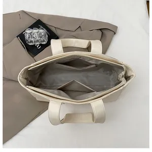 Close-up of the spacious interior with a zipper pocket in a cream PU leather tote bag