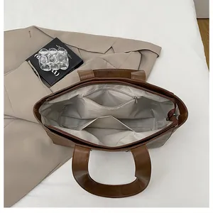Interior view of brown leather tote bag showing large capacity and zipper pocket