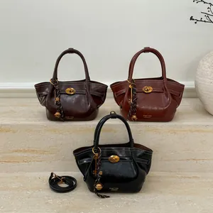 Three leather tote bags in dark brown, caramel, and black with elegant metal turn-locks
