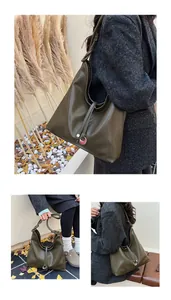 Detail view of olive green leather tote bag with unique knot strap and decorative pendant