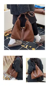 Detail of caramel brown hobo tote with knot handle and silver metal ring decoration