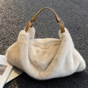 Sac à main en fausse fourrure crème avec anses en cuir marron sur fond gris texturé