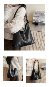 Detail of black leather hobo bag featuring a knotted shoulder strap and metal ring buckle