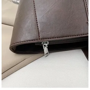 Macro shot of dark brown lychee texture leather detail and silver metal zipper on the handbag