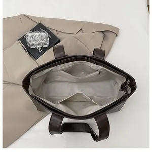 Internal view of dark brown tote bag showing zipper pocket and spacious compartments