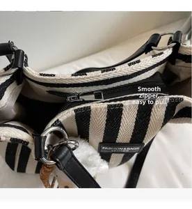 Detail showing smooth zipper closure and textured striped canvas of the tote bag