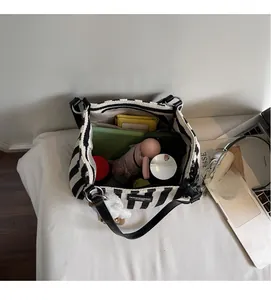 Detail of spacious interior of striped canvas tote bag showing storage for daily essentials